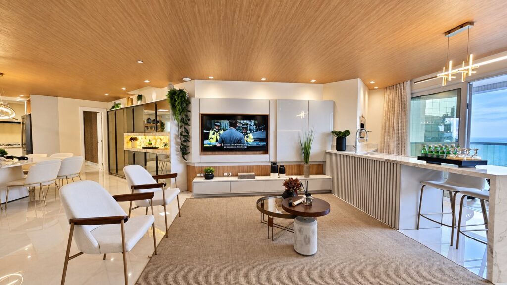 Living integrado de apartamento no Infinity Coast, com cozinha americana e vista para o mar