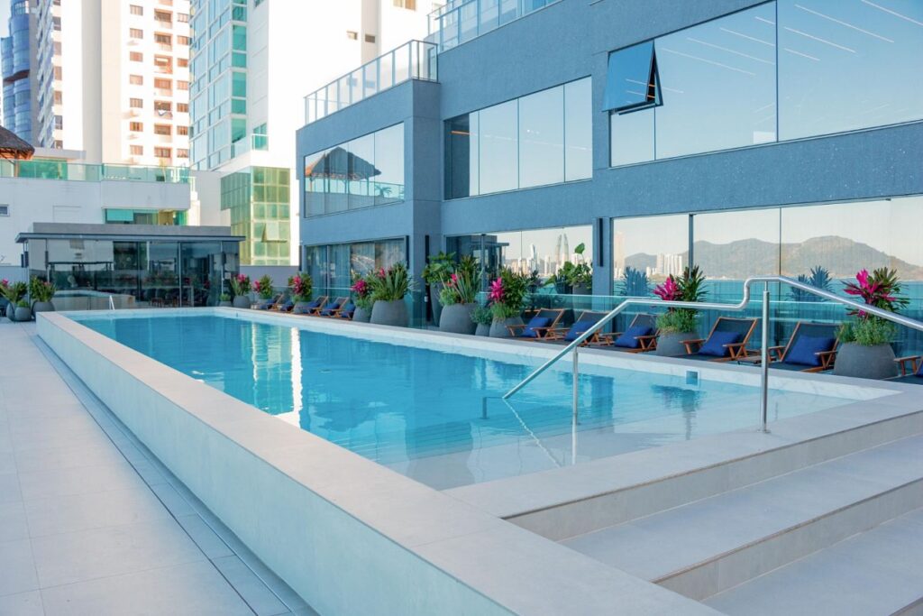 Piscina da área de lazer do Splendido, com deck e espreguiçadeiras, em Balneário Camboriú